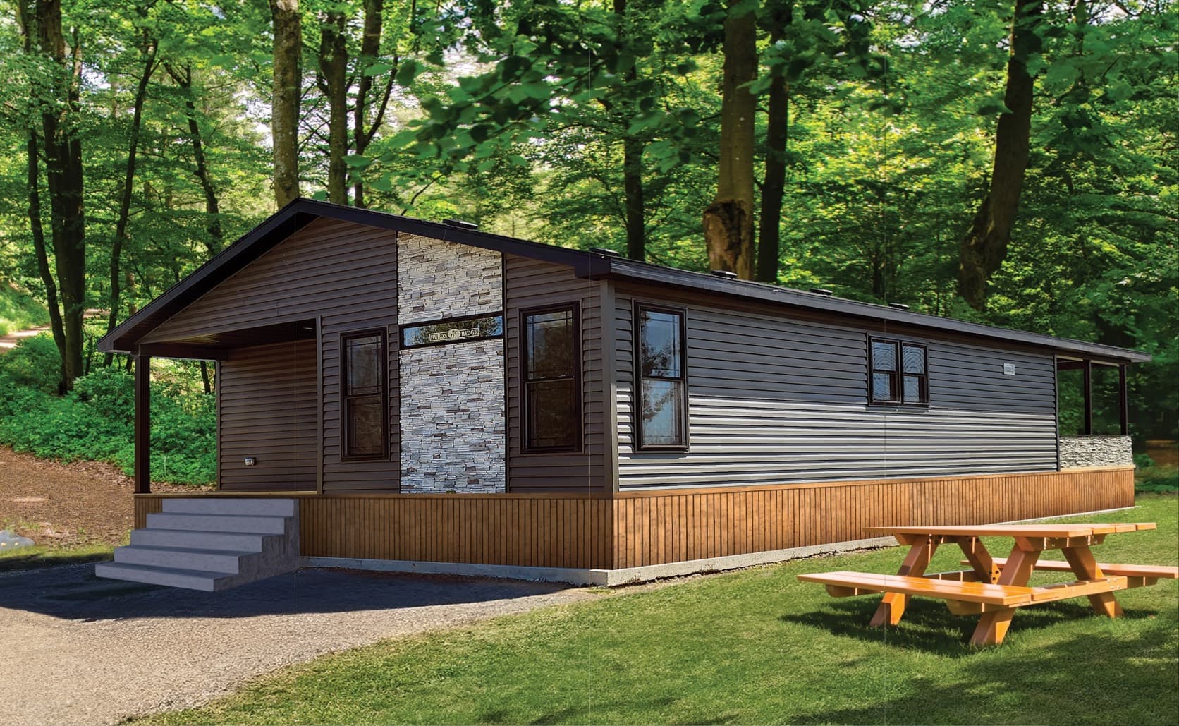 A General Coach Parkland Series modular home with a covered porch and stone accent, set among trees in Ontario